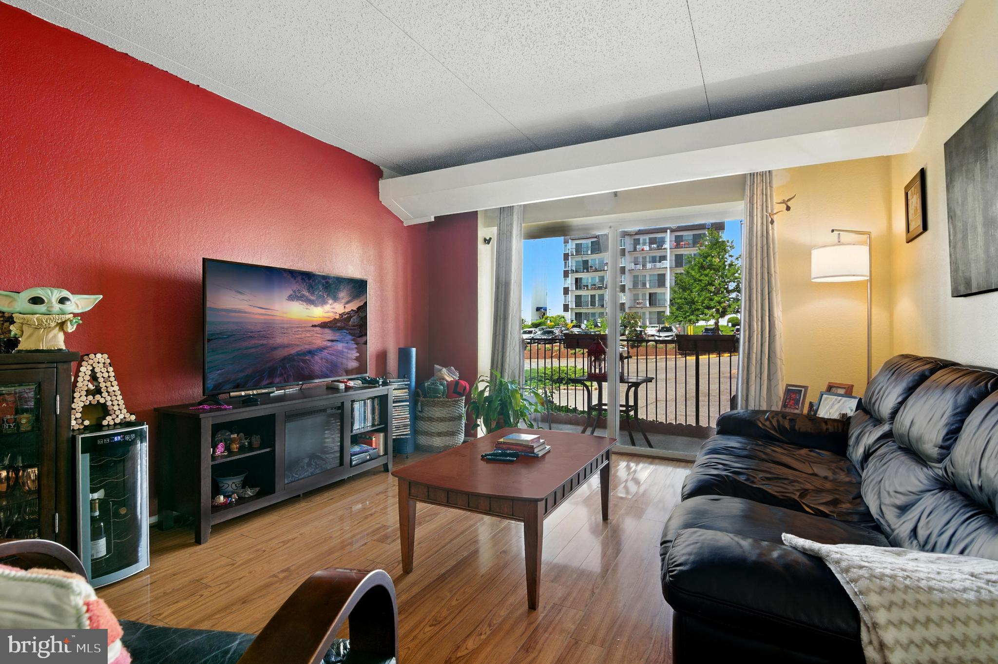 75 South Reynolds Street, Unit 101 Alexandria, VA 22304 - Photo 1 of 38 a living room with furniture a flat screen tv and a floor to ceiling window