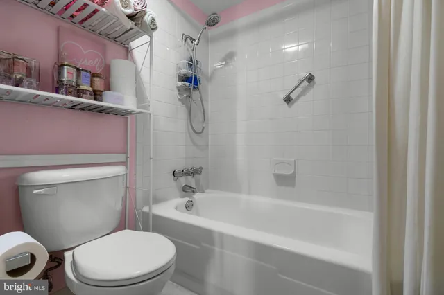 a white toilet sitting next to a bath tub