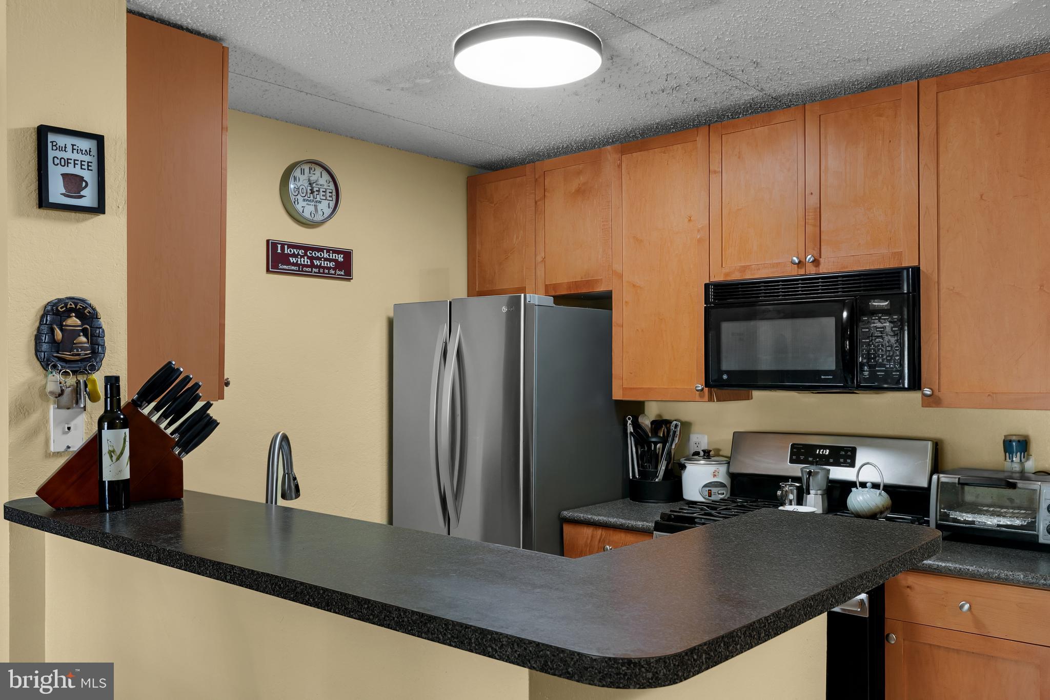 75 South Reynolds Street, Unit 101 Alexandria, VA 22304 - Photo 3 of 42 a kitchen with stainless steel appliances a sink a stove and a refrigerator