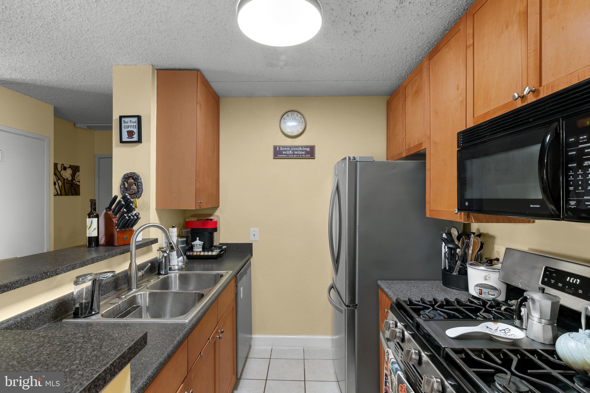75 South Reynolds Street, Unit 101 Alexandria, VA 22304 - Photo 5 of 38 a kitchen with stainless steel appliances granite countertop a sink stove and refrigerator