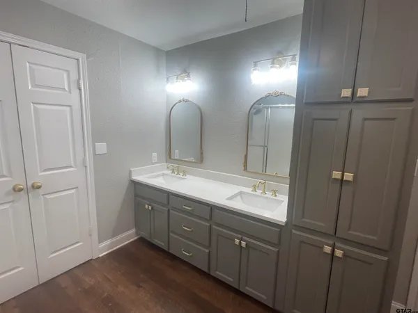 a bathroom with double vanity and a mirror