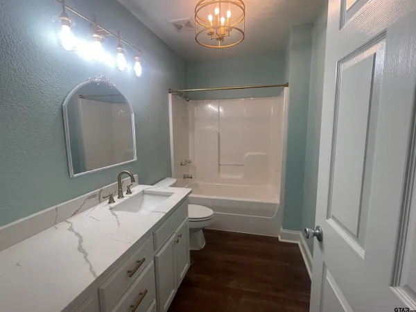 a bathroom with a double vanity sink a toilet and a mirror