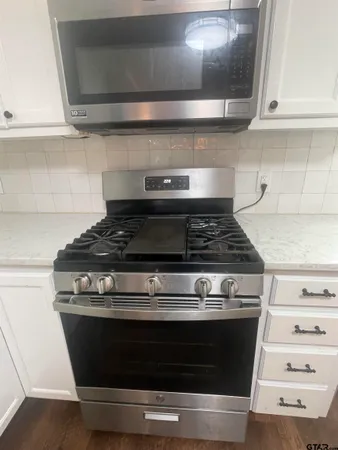 a stove top oven sitting inside of a kitchen