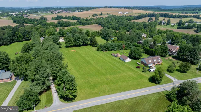 an aerial view of green landscape with trees houses and mountain view