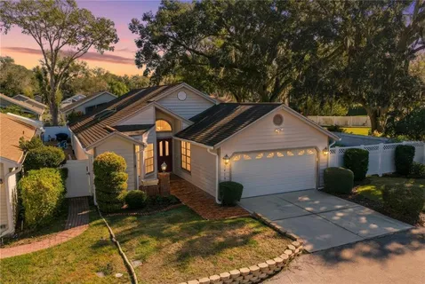 a front view of house with yard and trees in the background