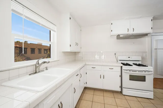 a kitchen with granite countertop white cabinets and white appliances
