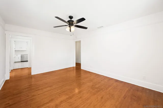 a view of a big room with wooden floor closet and windows