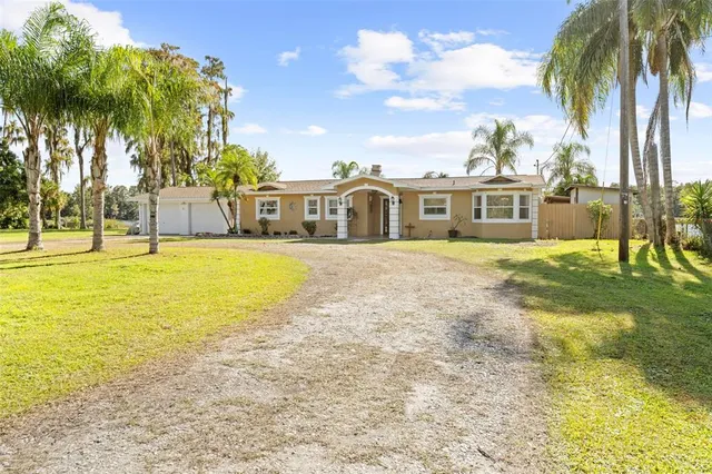 a view of a house with a swimming pool and a big yard