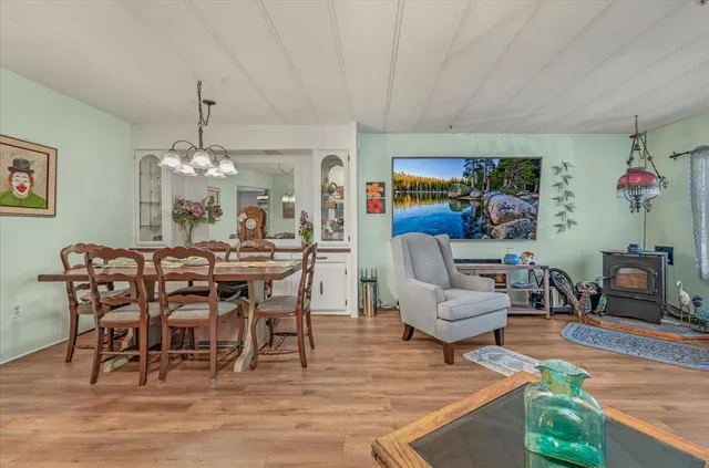 a kitchen with stainless steel appliances granite countertop a stove top oven a sink dishwasher a dining table and chairs with wooden floor