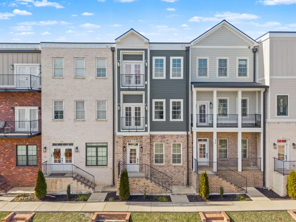 a front view of a residential apartment building with a yard