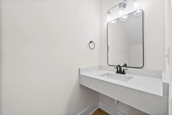 a kitchen with stainless steel appliances a stove a sink dishwasher a refrigerator and white cabinets with wooden floor