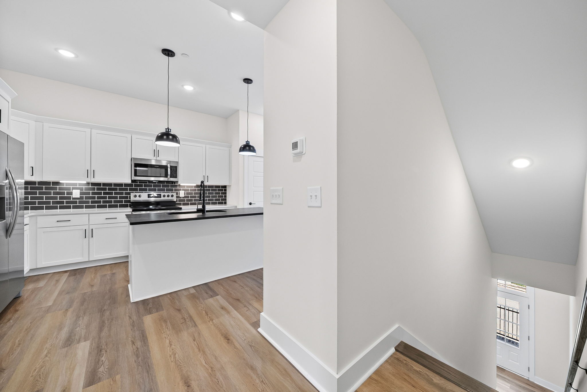 442 Centre Street Pleasant View, TN 37146 - Photo 16 of 47 a kitchen with stainless steel appliances granite countertop a refrigerator a stove and white cabinets with wooden floor