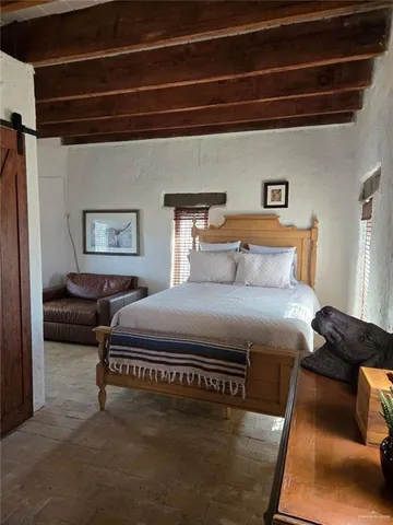 a bedroom with a bed couch and a window