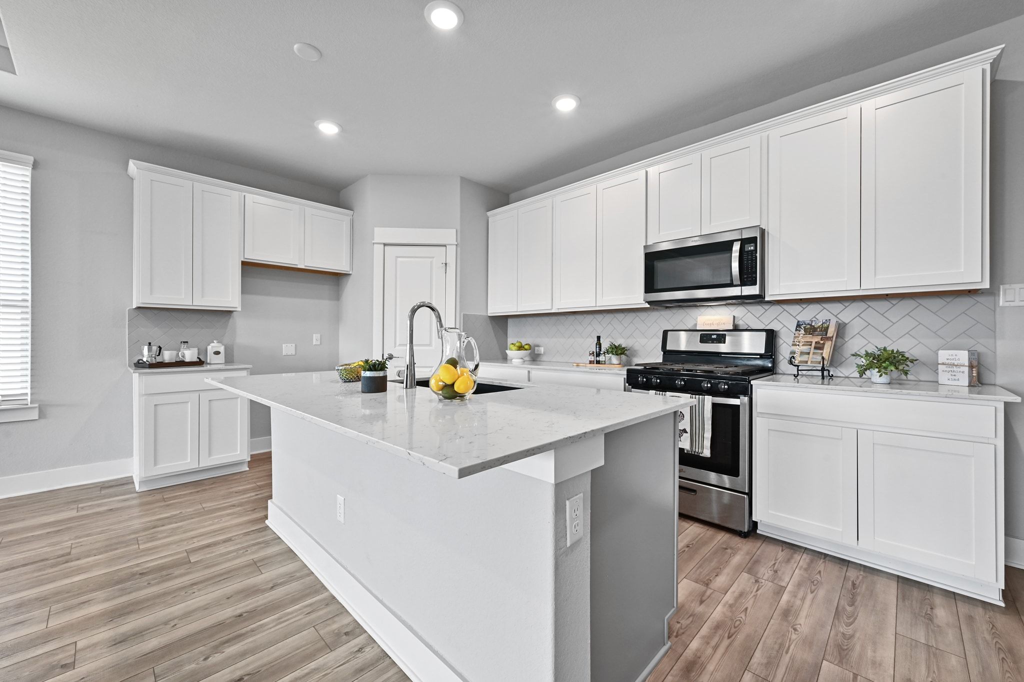 284 Grace Lilly Drive Buda, TX 78610 - Photo 11 of 40 a kitchen with white cabinets stainless steel appliances and sink