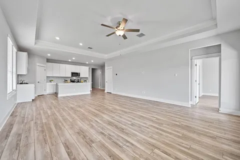 a view of a room with kitchen island stainless steel appliances wooden floor and living room view
