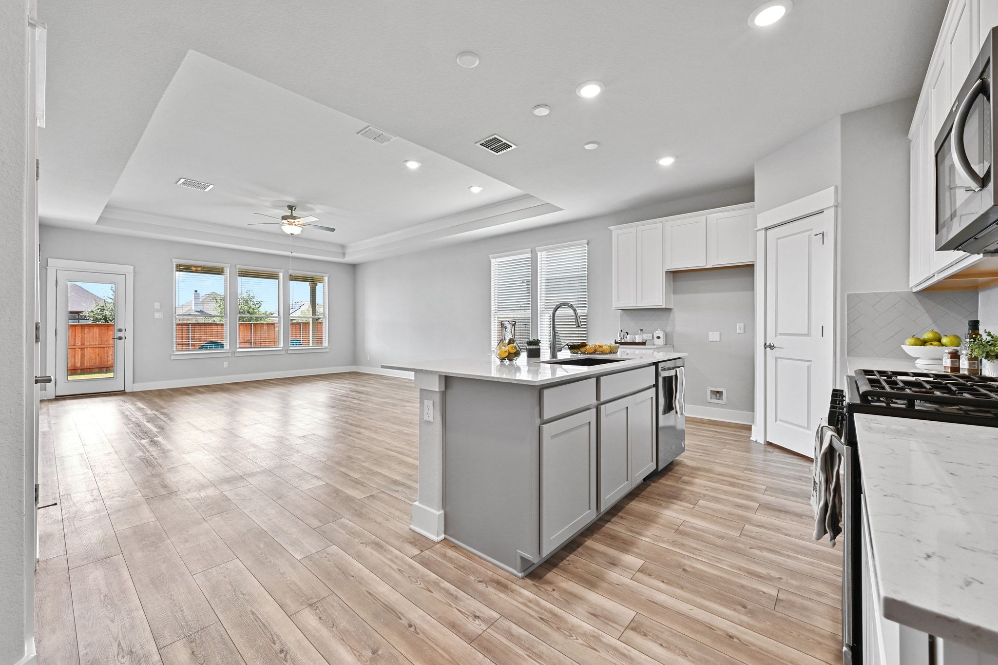 284 Grace Lilly Drive Buda, TX 78610 - Photo 9 of 40 a kitchen with stainless steel appliances granite countertop a stove top oven a sink dishwasher a refrigerator and white cabinets with wooden floor