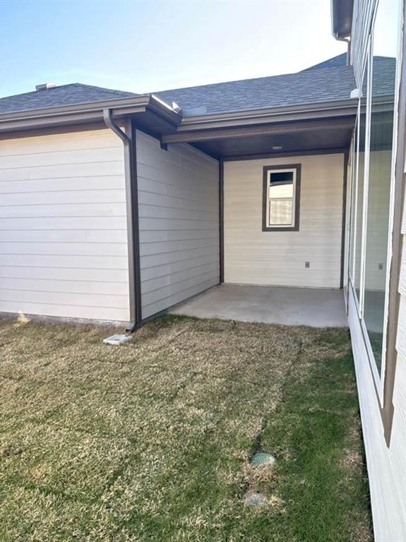 7013 Lathrop Lane Frisco, TX 75033 - Photo 25 of 26 Back of property with a yard, a shingled roof, and a patio