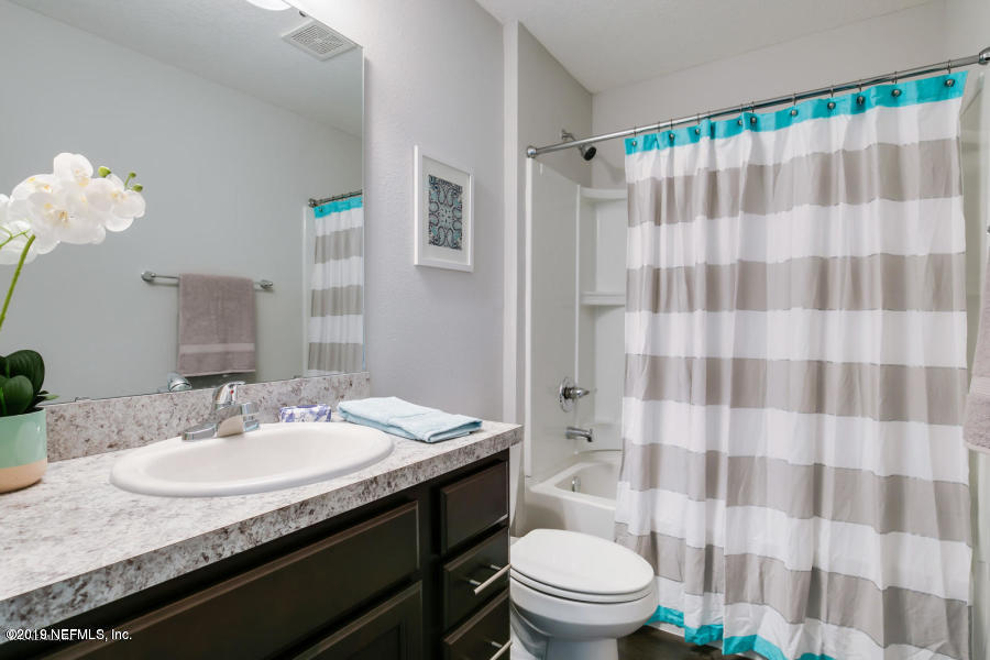 2253 Bayview Road Jacksonville, FL 32210 - Photo 15 of 15 a bathroom with a granite countertop sink a toilet and a shower curtain