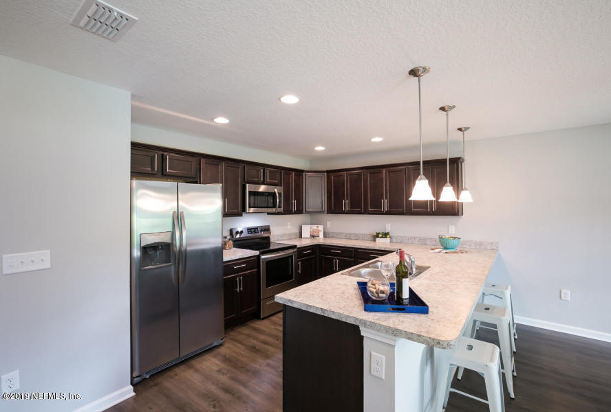 2253 Bayview Road Jacksonville, FL 32210 - Photo 9 of 15 a kitchen with kitchen island a sink counter top space stainless steel appliances and cabinets