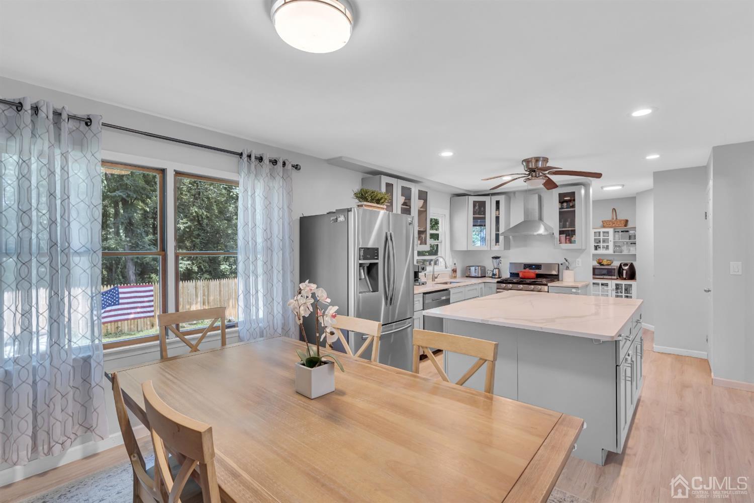 76 Bethany Road Hazlet, NJ 07730 - Photo 12 of 33 a dining room with kitchen island stainless steel appliances furniture a large window and kitchen view