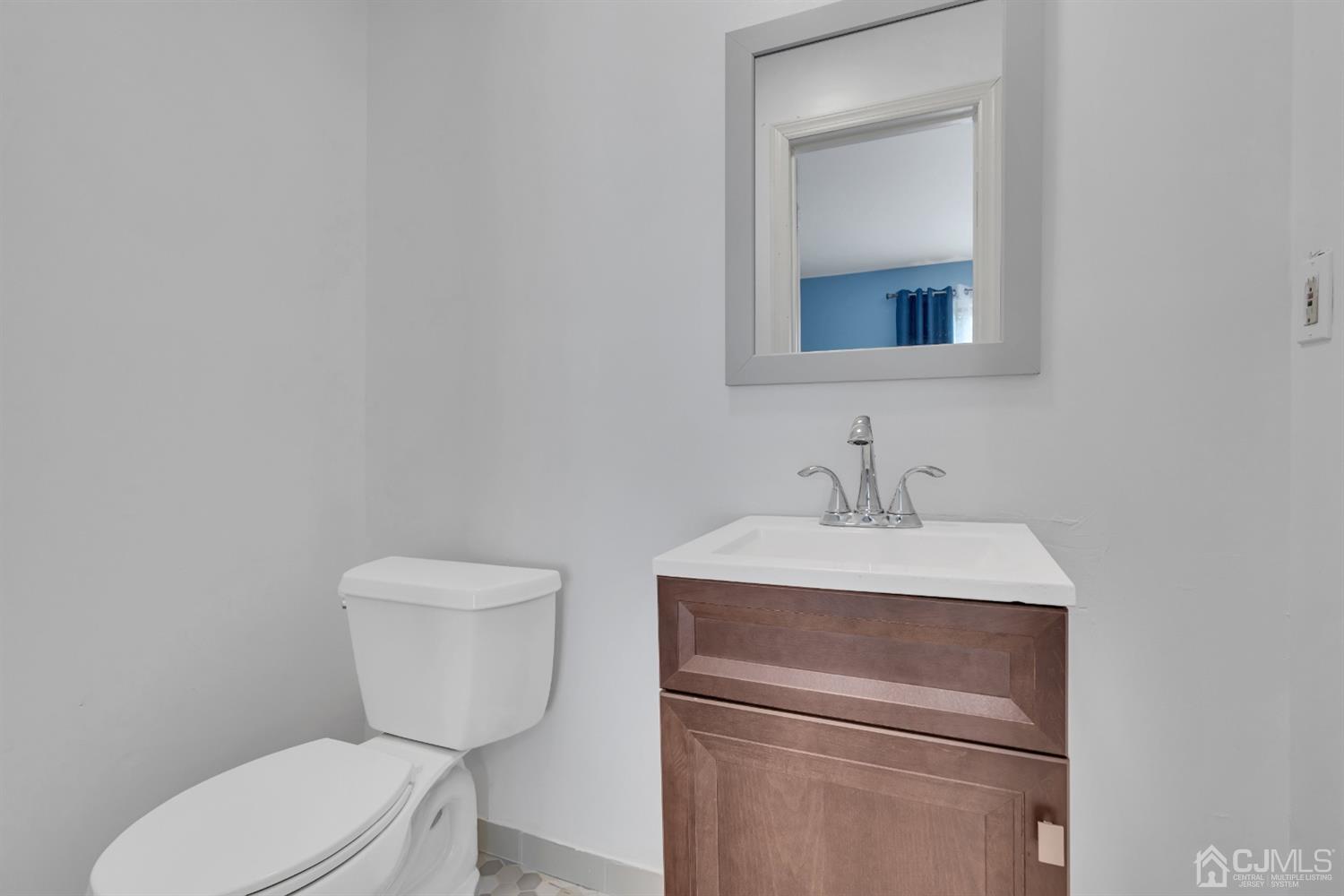 76 Bethany Road Hazlet, NJ 07730 - Photo 25 of 33 a bathroom with a toilet sink vanity and mirror
