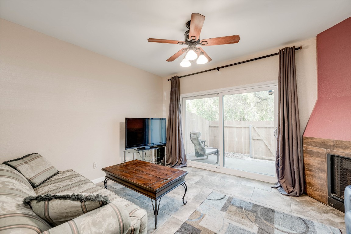 11821 Bittern Hollow, Unit 34 Austin, TX 78758 - Photo 2 of 24 Living room with a ceiling fan and a fireplace