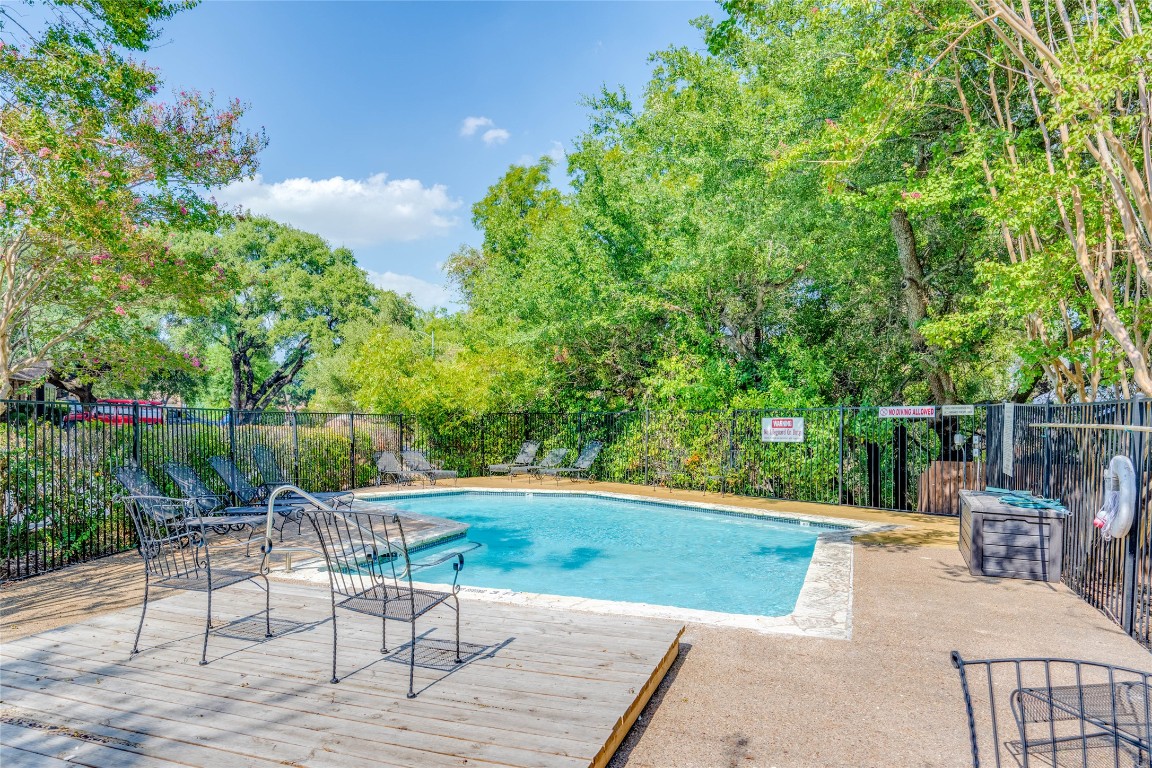 11821 Bittern Hollow, Unit 34 Austin, TX 78758 - Photo 21 of 24 Community pool featuring view of wooded area and a deck