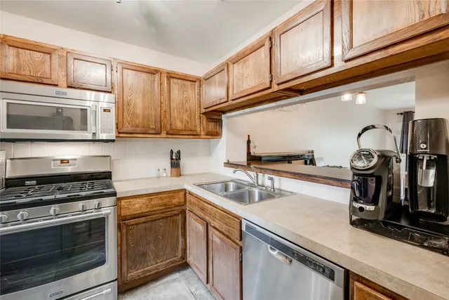 a kitchen with stainless steel appliances granite countertop a sink stove top oven and microwave