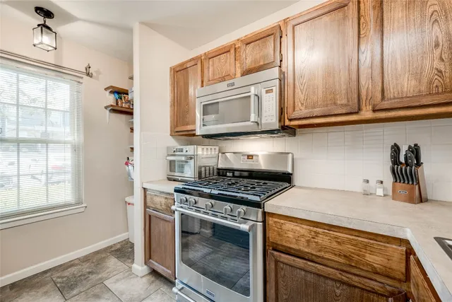 a kitchen with granite countertop cabinets stainless steel appliances and a window