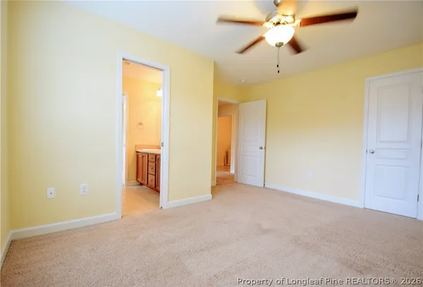 an empty room with a ceiling fan and a window