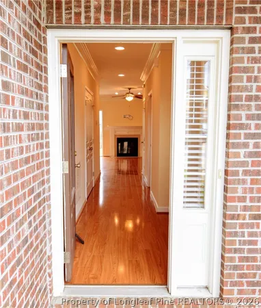 a view of a hallway with wooden floor and staircase