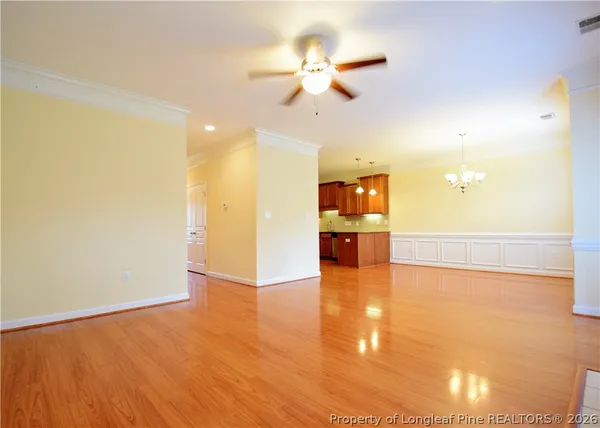 a view of an empty room and kitchen view
