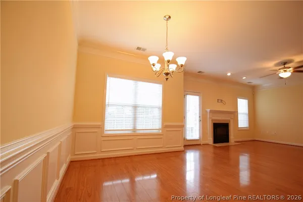 a view of a livingroom with a chandelier wooden floor and chandelier