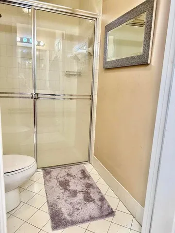a bathroom with a granite countertop toilet and a shower