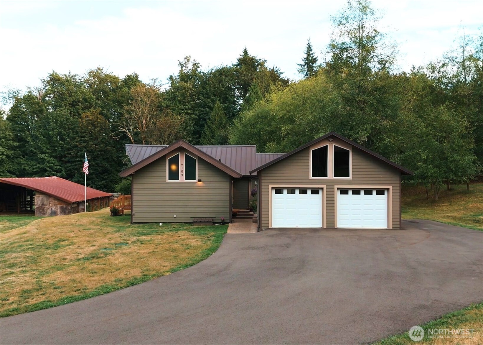 6103 Lackey Road Northwest Vaughn, WA 98394 - Photo 2 of 37 a house that has a big yard plants and large trees with wooden fence