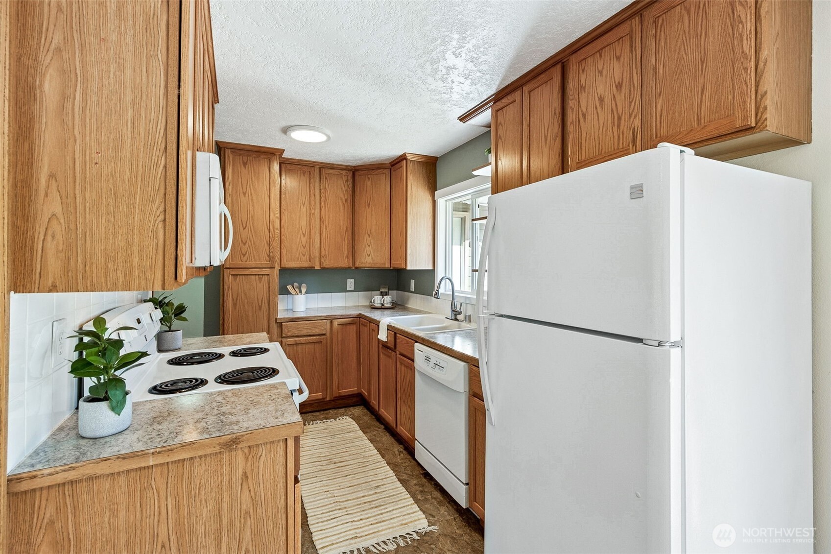 6103 Lackey Road Northwest Vaughn, WA 98394 - Photo 21 of 37 a white refrigerator freezer sitting inside of a kitchen