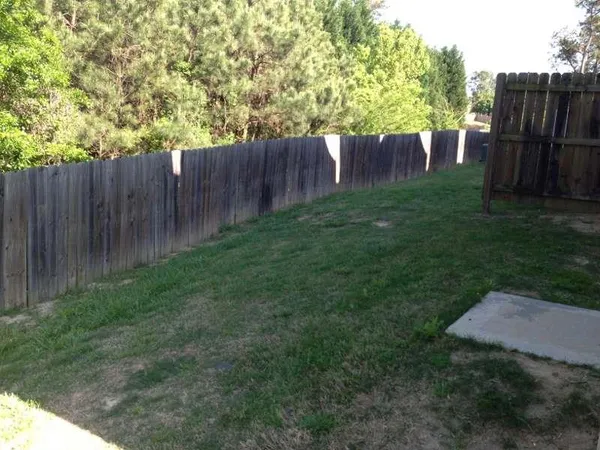 a view of backyard with wooden fence