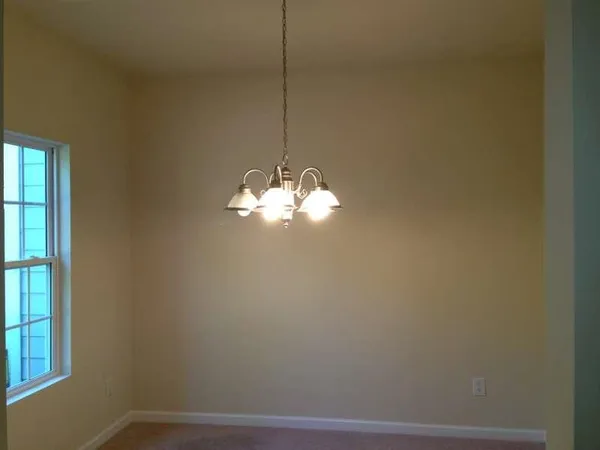 a view of a small space with a chandelier fan