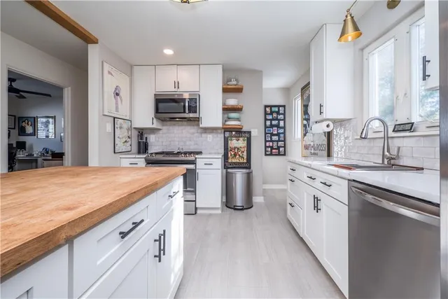 a kitchen with cabinets stainless steel appliances and a window