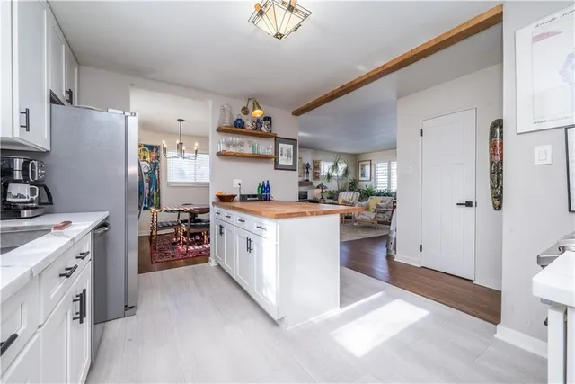 a kitchen with stainless steel appliances granite countertop a stove a sink dishwasher and a refrigerator with wooden table