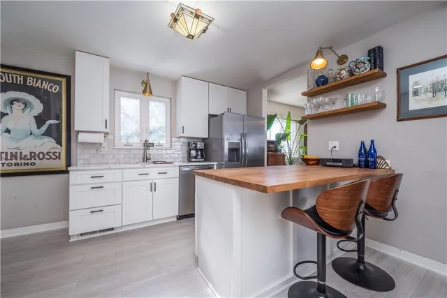 a kitchen with stainless steel appliances granite countertop a sink a stove and a microwave