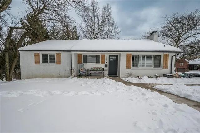 a view of a house with a yard covered in snow