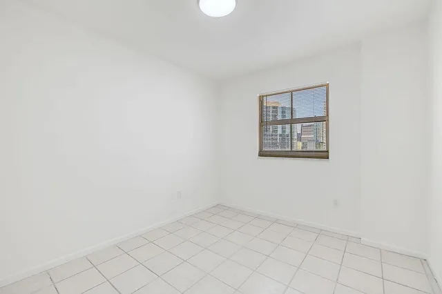 an empty room with a white wall and a window