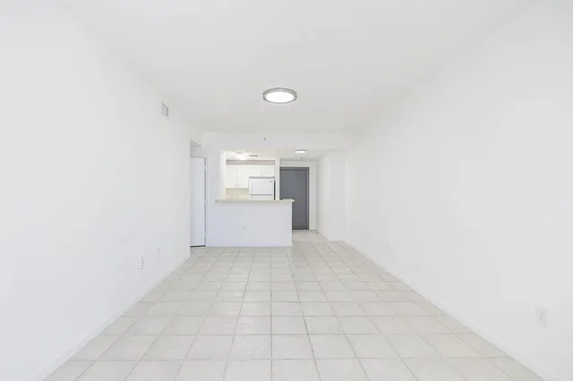 a view of an empty room with a kitchen