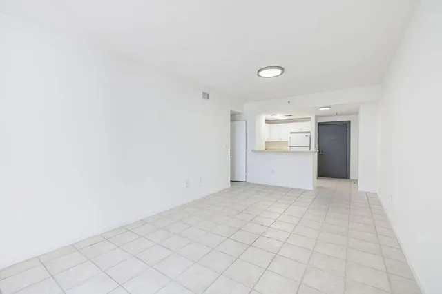 a view of an empty room with window and cabinet