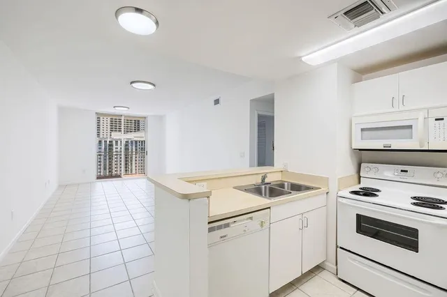 a kitchen that has a sink and white cabinets