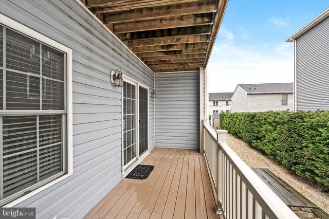 a view of balcony with wooden floor and floor to ceiling window