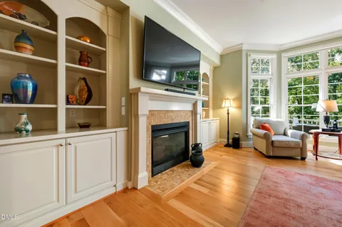 a large kitchen with stainless steel appliances granite countertop a large kitchen island a stove a sink a refrigerator and white cabinets with wooden floor