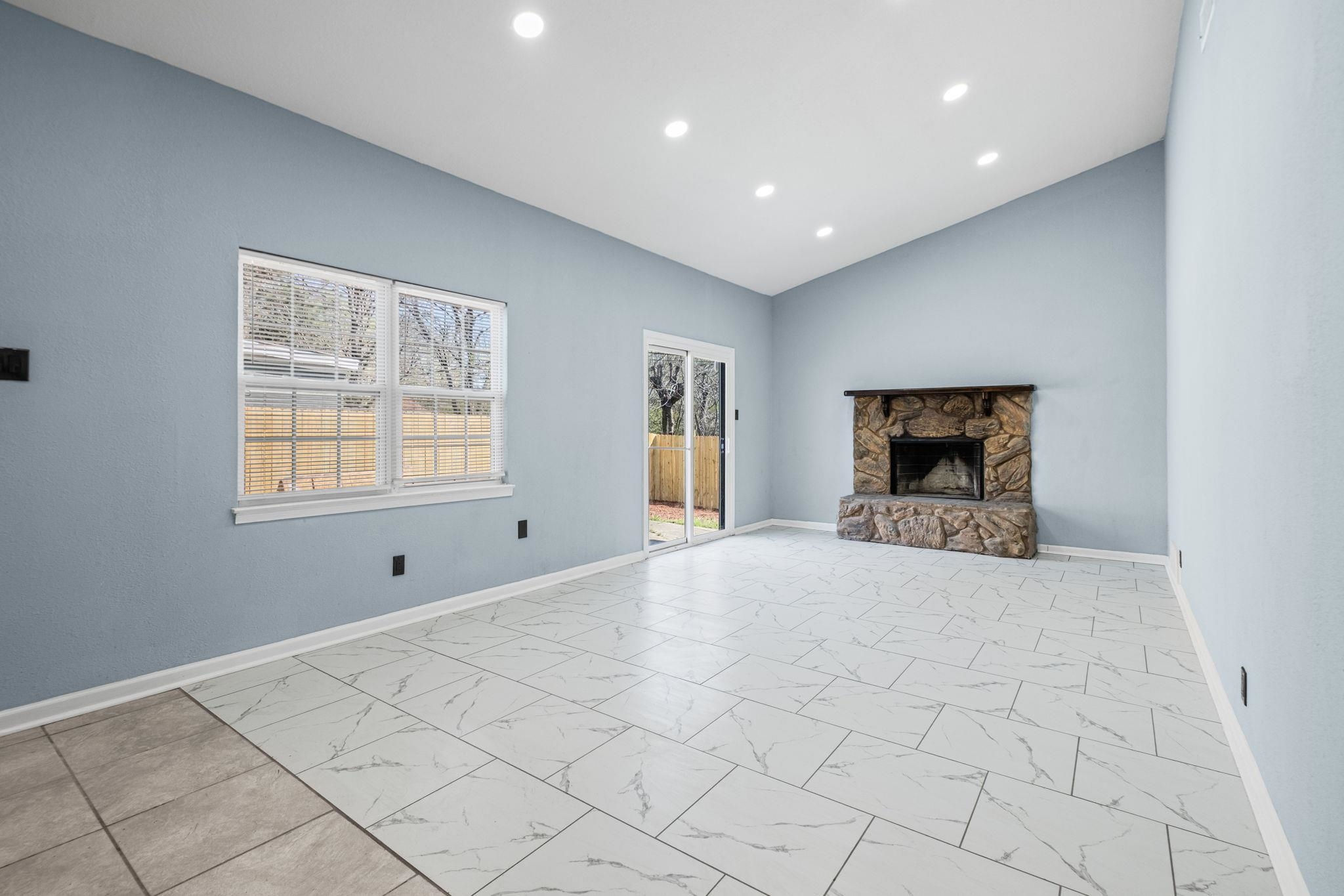 3793 Tessland Road Memphis, TN 38128 - Photo 11 of 22 Unfurnished living room with a stone fireplace, lofted ceiling, recessed lighting, and light marble finish floors