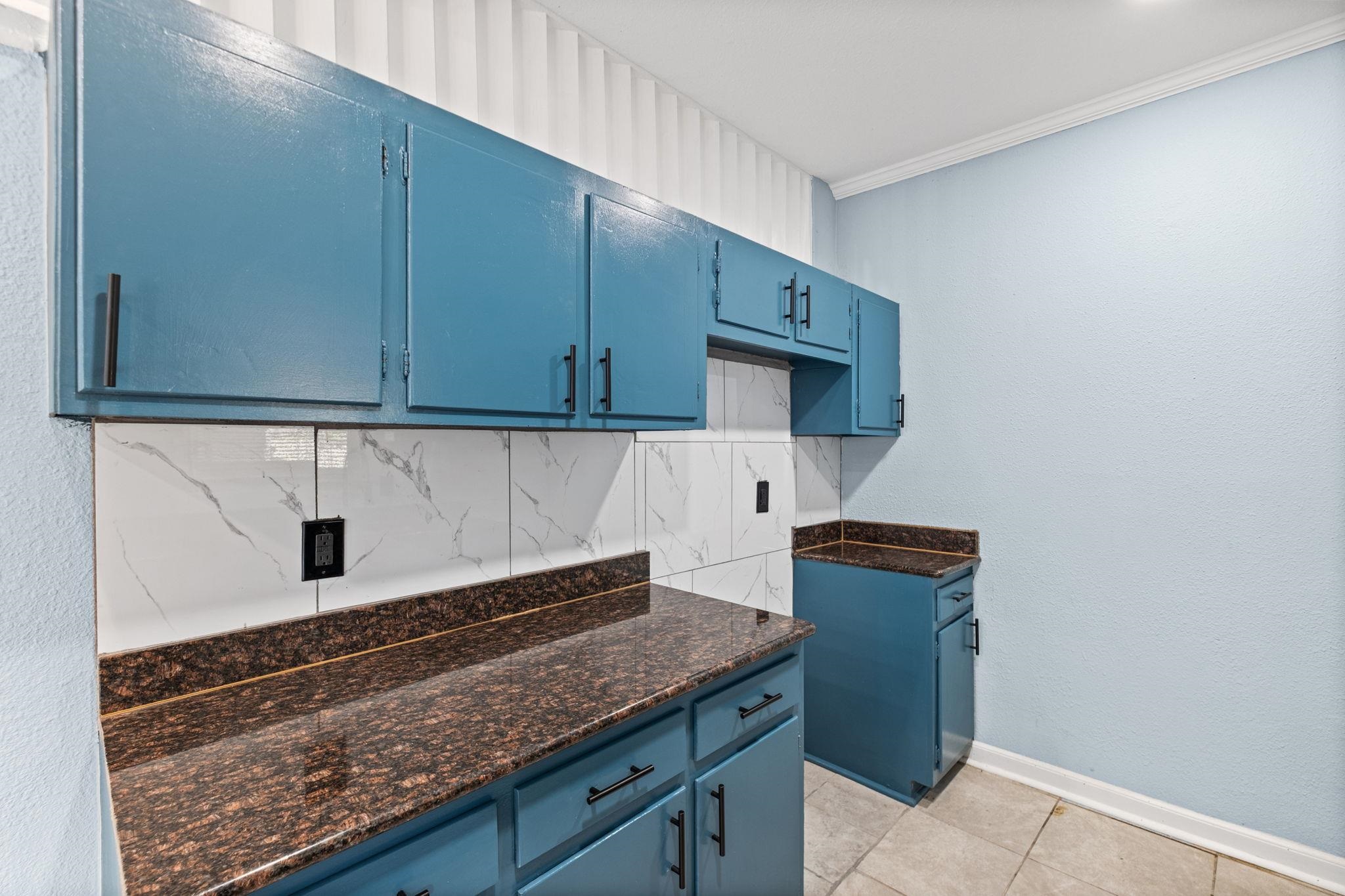 3793 Tessland Road Memphis, TN 38128 - Photo 7 of 22 Kitchen with blue cabinetry, backsplash, crown molding, a textured wall, and light tile patterned floors